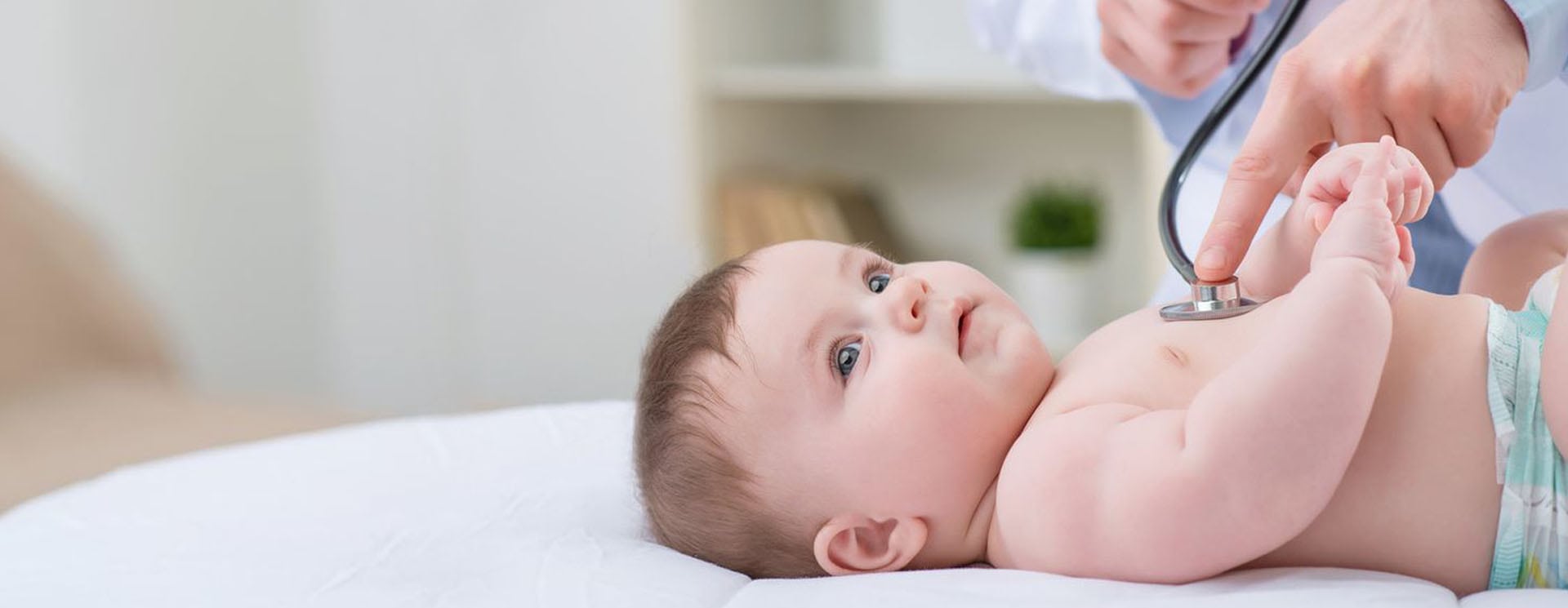 A baby laying on its back in the bed