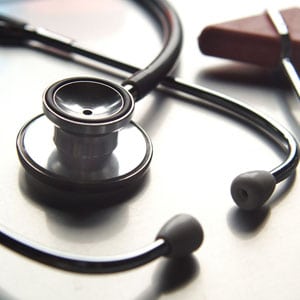 A stethoscope and ear buds on top of a table.