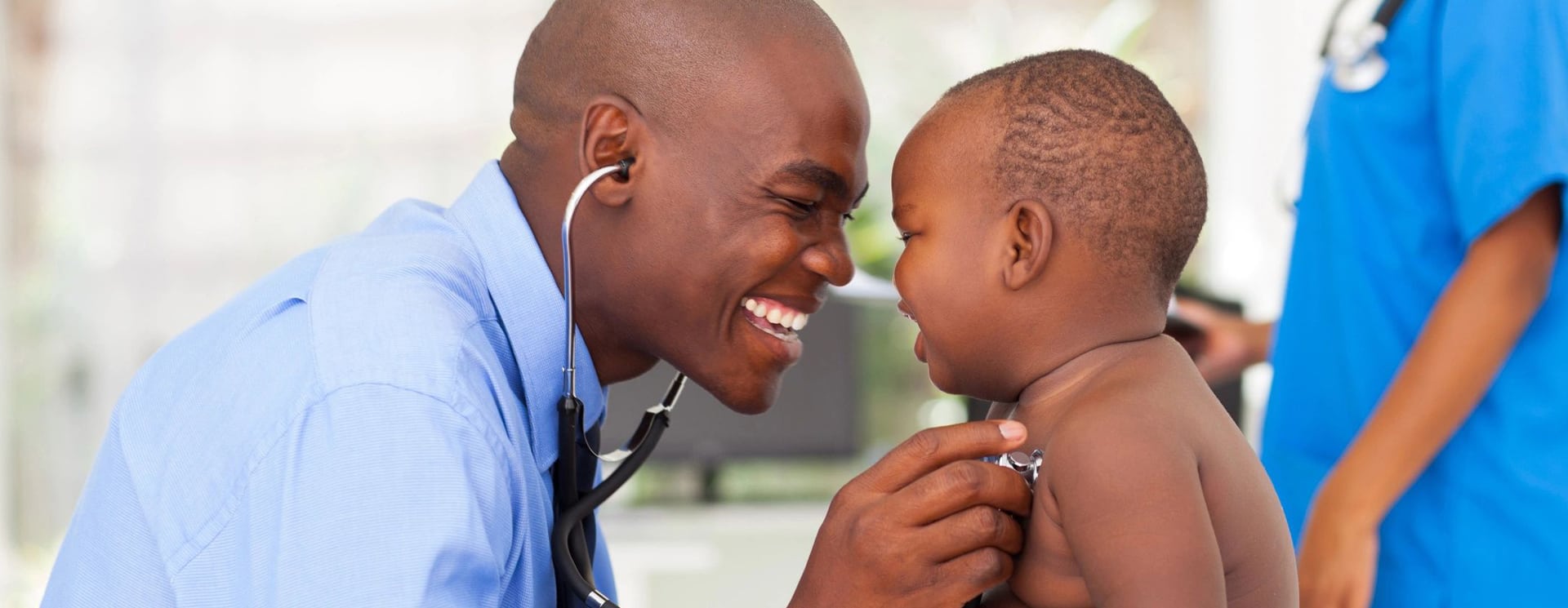 A doctor is holding the ear of a child.