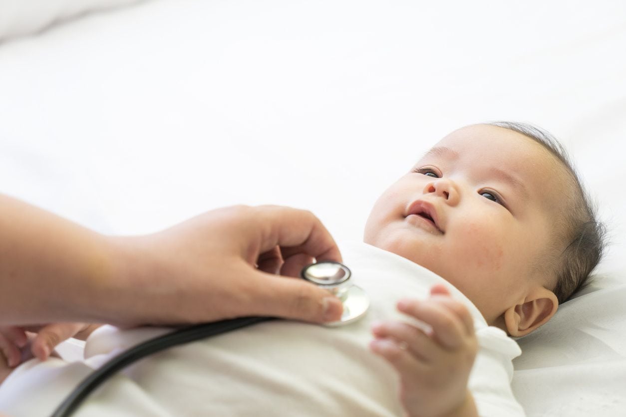 A baby is being examined by an adult.