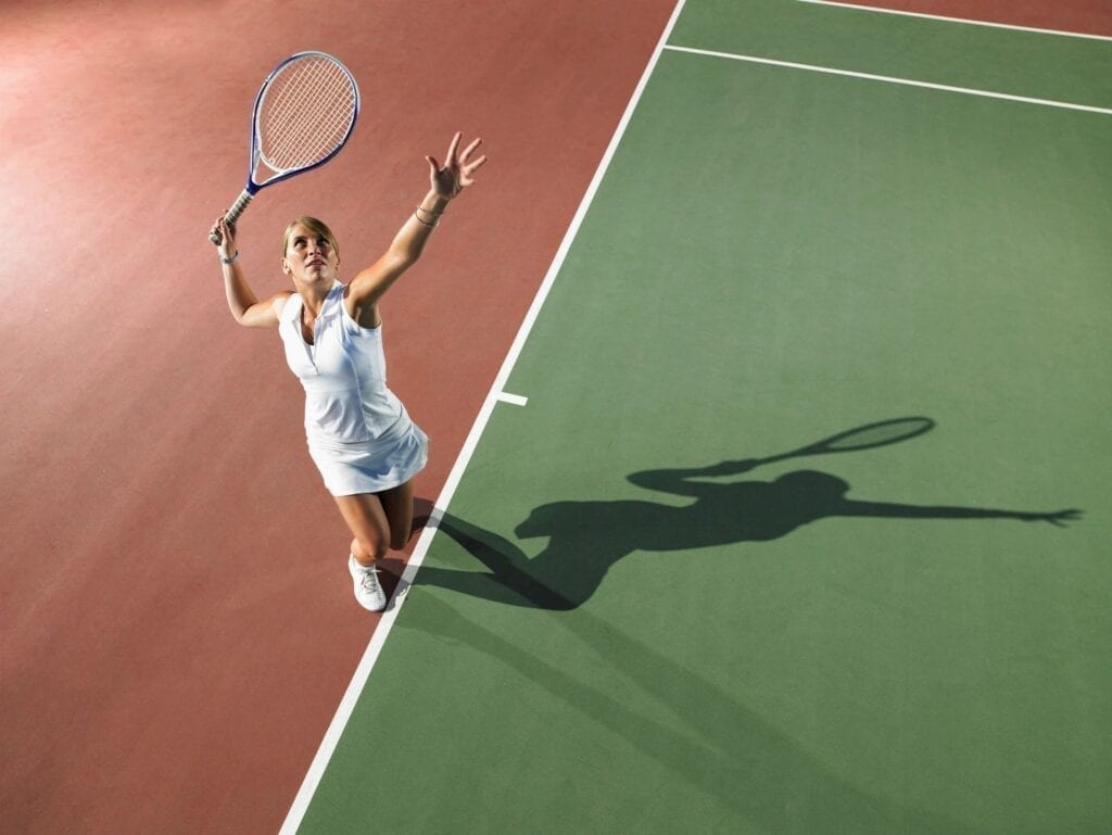 A woman holding a tennis racket on top of a court.